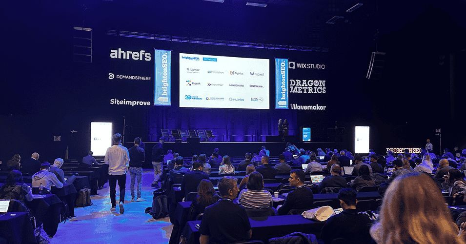 Picture taken from Brighton SEO, with a screen of all the sponsors and audience in attendance